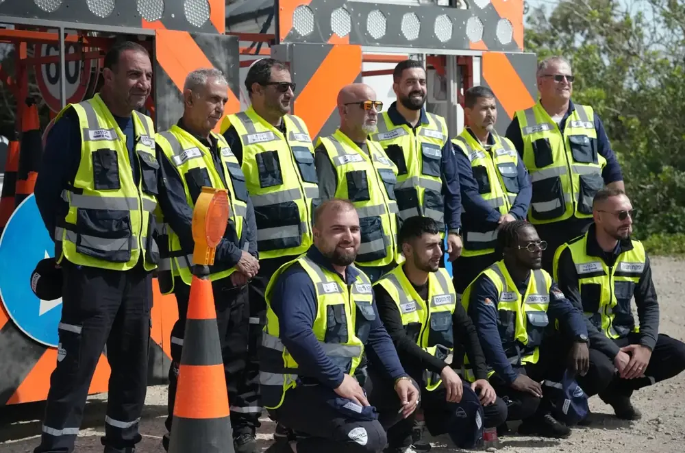 צוות פקחי התנועה של פיקוח והכוונה במדים, מול עגלות חץ